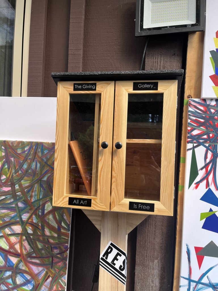 Giving Gallery cabinet installed with Gallery, Giving, Is Free, and Art labels
