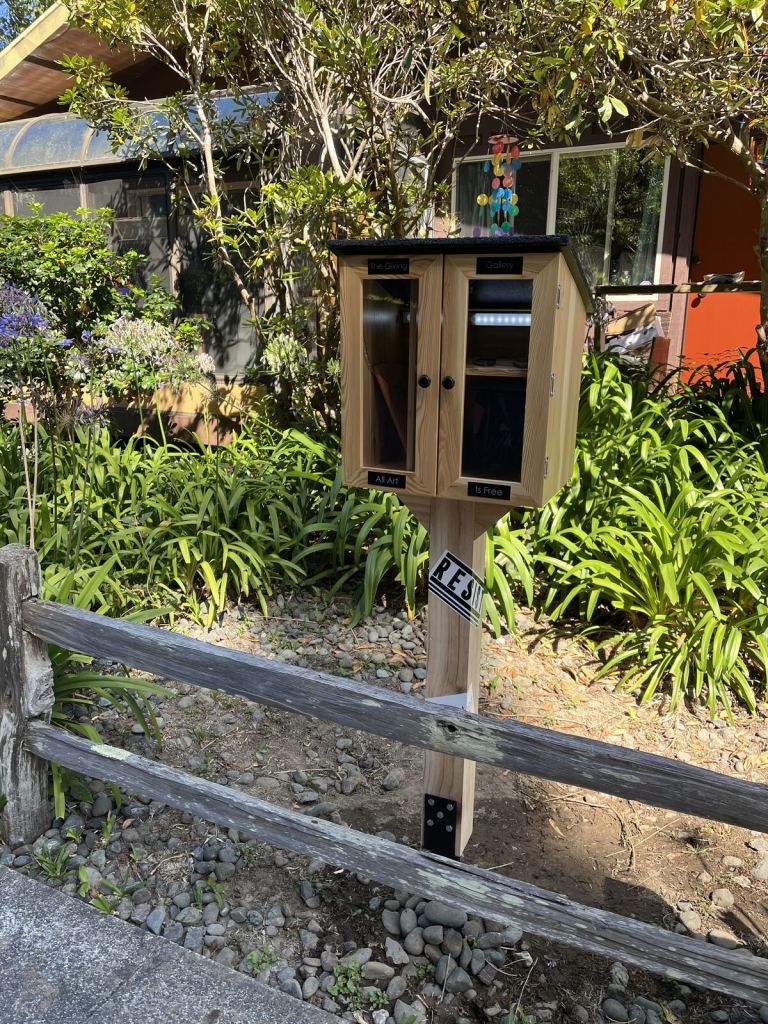 Giving Gallery cabinet installed outdoors beside the path