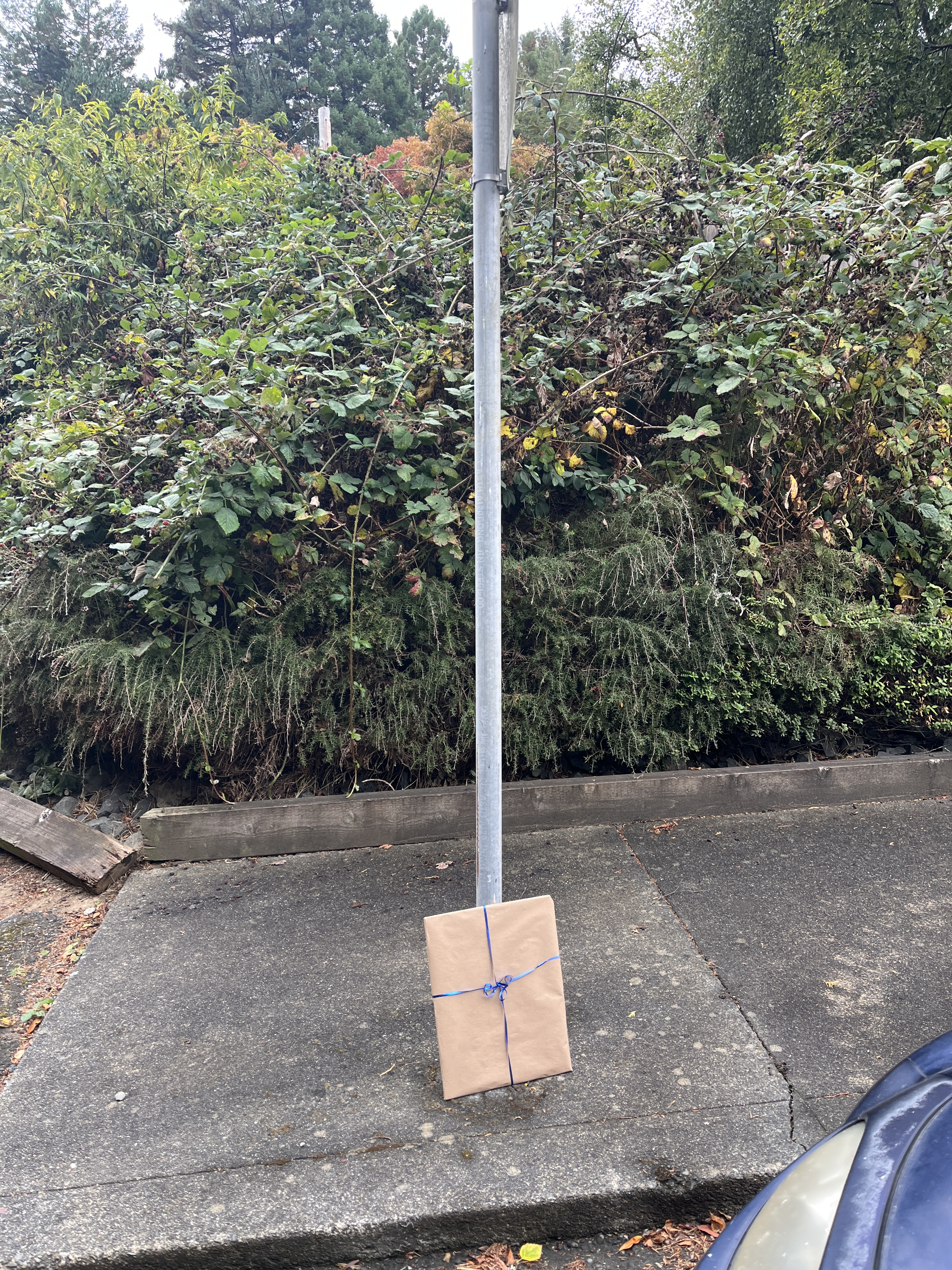 Art Drop #10: gift-wrapped artwork left beside a metal pole